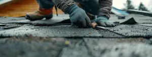 a close-up view of a professional contractor skillfully applying a waterproof sealant to a damaged roof in a modern suburban home setting, with tools and repair materials visibly arranged nearby.